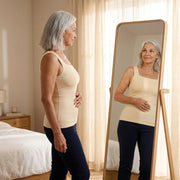 Woman checking the Maddietanks built-in bra tank in a bedroom mirror
