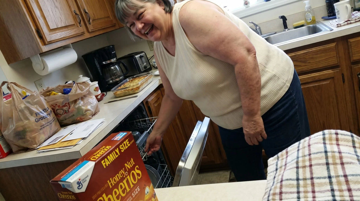 A woman unloading the dishwasher in her kitchen on an ordinary afternoon