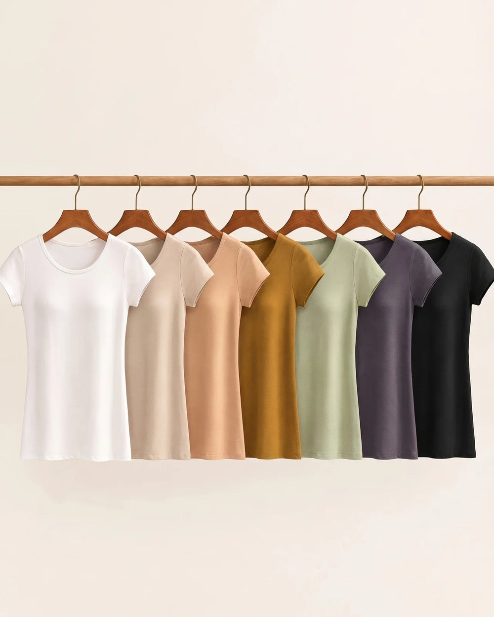 All seven colours of Maddie's built-in bra tee hanging on a wooden rail