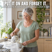 Woman in her sixties pouring tea in a sunlit kitchen wearing the Maddietanks built-in bra short-sleeve tee in sage green